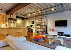 a living room filled with lots of furniture and a flat screen tv mounted to the wall