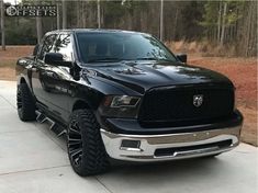 a black ram truck parked on top of a driveway