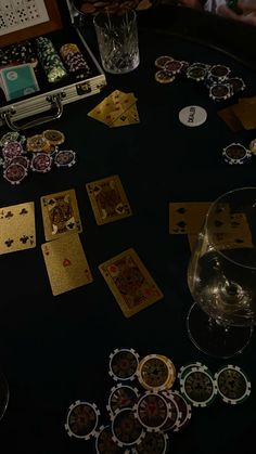 the table is full of playing cards and wine glasses