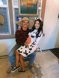 a man and woman in costumes pose for a photo while sitting on a chair together