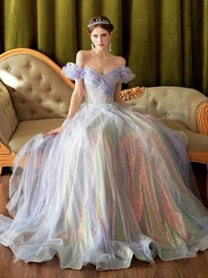 a woman sitting on a couch wearing a dress with sequins and a tiara