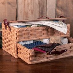 two baskets with ties and wallets in them sitting on a wooden table next to other items