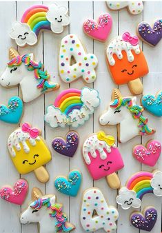 decorated cookies are arranged in the shape of rainbows, unicorns, and hearts