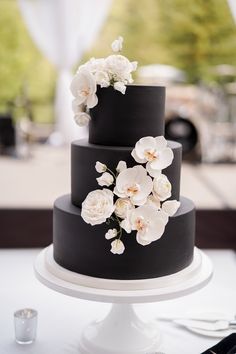 a black and white wedding cake with flowers on top