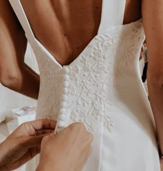 a woman in a white dress getting ready to go on her wedding day