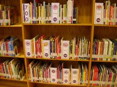 a book shelf filled with lots of books on top of wooden shelves next to each other