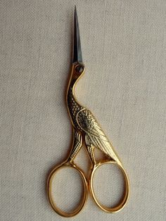 a pair of gold scissors sitting on top of a table