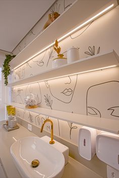 a white sink sitting under a bathroom mirror next to a wall mounted faucet