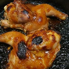 two pieces of chicken cooking in a skillet