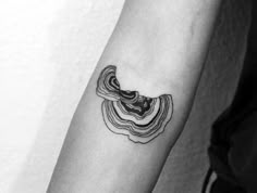 a black and white photo of a woman's arm with a wave tattoo on it