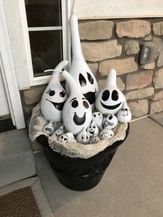 a group of ghost statues sitting on top of a black pot next to a door