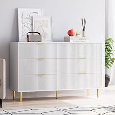 a white dresser sitting next to a chair in a living room