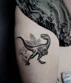 a woman's thigh with a dinosaur tattoo on it