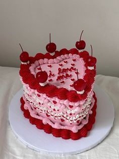 a heart shaped cake with cherries on top