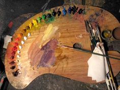 an artist's palette with paints and brushes