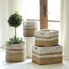 three wicker baskets sitting next to a window with a potted plant in it