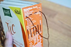 a person is holding an orange and white book with writing on the front cover that reads nutrition fact