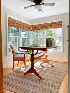 a room with a table, chairs and a ceiling fan in the middle of it