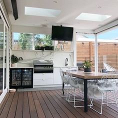 an outdoor kitchen and dining area with sliding glass doors