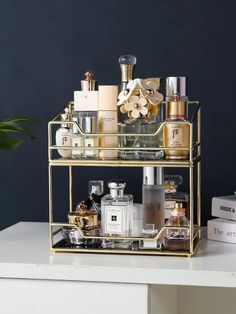 a gold metal shelf with perfumes and bottles on it