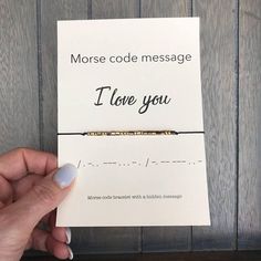 a hand holding a note that says morse code message i love you