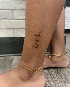 a woman's foot with a tattoo that reads, walk by faith on it