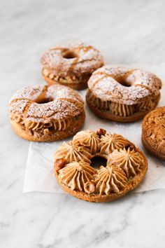 four donuts sitting on top of a white counter