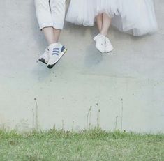 two people in white dresses are standing next to each other with their feet on the ground