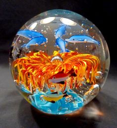 a close up of a glass ball with dolphins in the water and bubbles on it