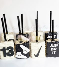 there are four cakes that have numbers on them and black sticks sticking out of them