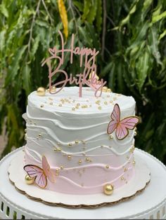 a birthday cake with pink and gold butterflies on it