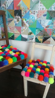 two chairs with colorful pom - poms on them in front of a wall