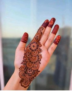 a woman's hand with henna tattoos on it