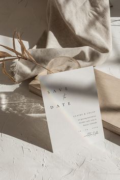 an open book on a table next to a sheet of paper that says save the date