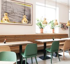 an empty restaurant with wooden tables and green chairs