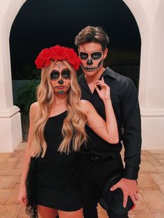 a man and woman in skeleton makeup standing next to each other