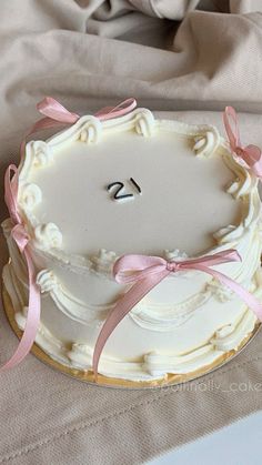 a white cake with pink ribbon and the number twenty on it