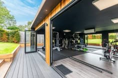 an outdoor gym area with exercise equipment on the floor and large sliding glass doors leading outside