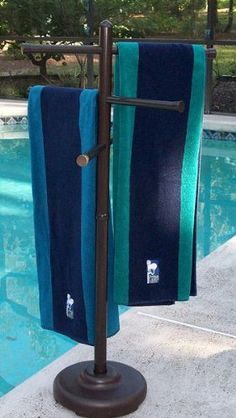 two towels hanging on a towel rack next to a pool