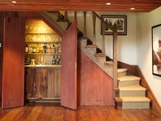 a wooden staircase leading up to a bar in a room with wood floors and walls