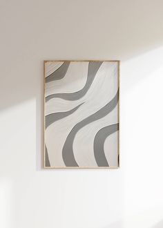 an abstract painting hangs on the wall above a bed