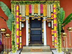 an entrance to a building decorated with flowers and garlands on the front door area