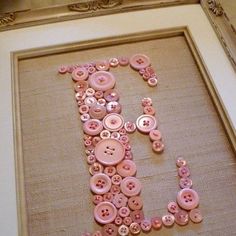 the letter j is made up of pink buttons and some other things in front of it