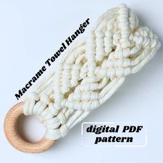 a white crocheted object with a wooden ring on it's end and text reading machine towel holder digital pattern