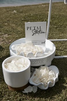 there are two bowls with whipped cream in them on the grass next to a sign that says petal spa