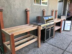 an outdoor bbq with grills and benches next to it