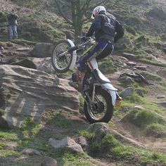 a person on a dirt bike jumping over rocks