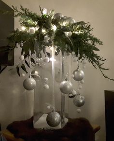 a christmas tree with ornaments hanging from it's branches and lights on the top