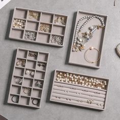 jewelry is displayed in trays on a table next to other items, including rings and bracelets