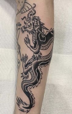 a man's arm with a dragon tattoo on it and an arrow in the middle